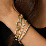 Twist Link Bracelet + Lisse Tennis Bracelet +Little White Diamond Cuff close up on woman's wrist