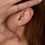 Close up of woman's ear with 6mm Sculpted Link Gold Earrings + White Diamond Abstract Bezel Studs
