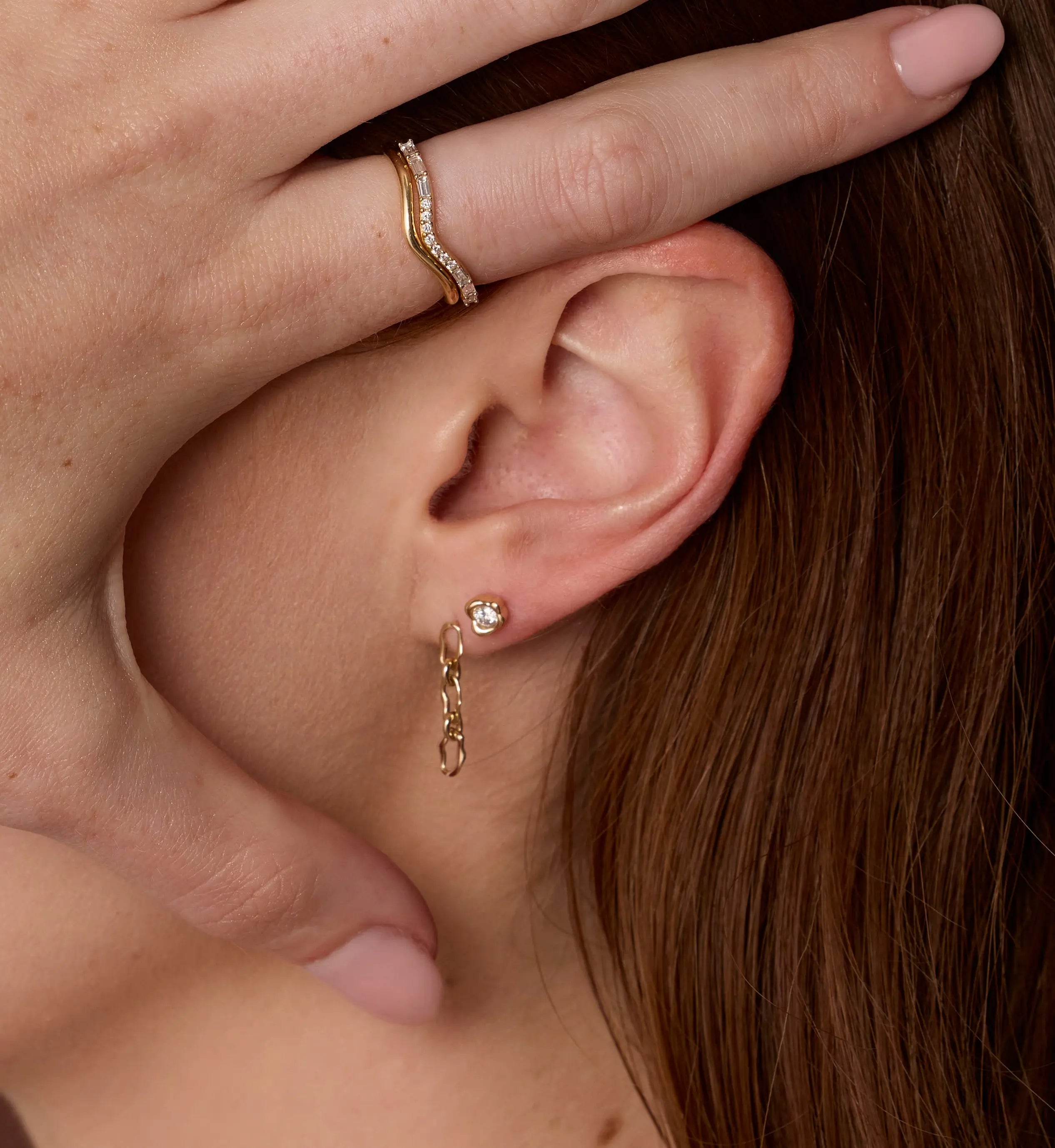 Close up of woman's ear with 6mm Sculpted Link Gold Earrings + White Diamond Abstract Bezel Studs
