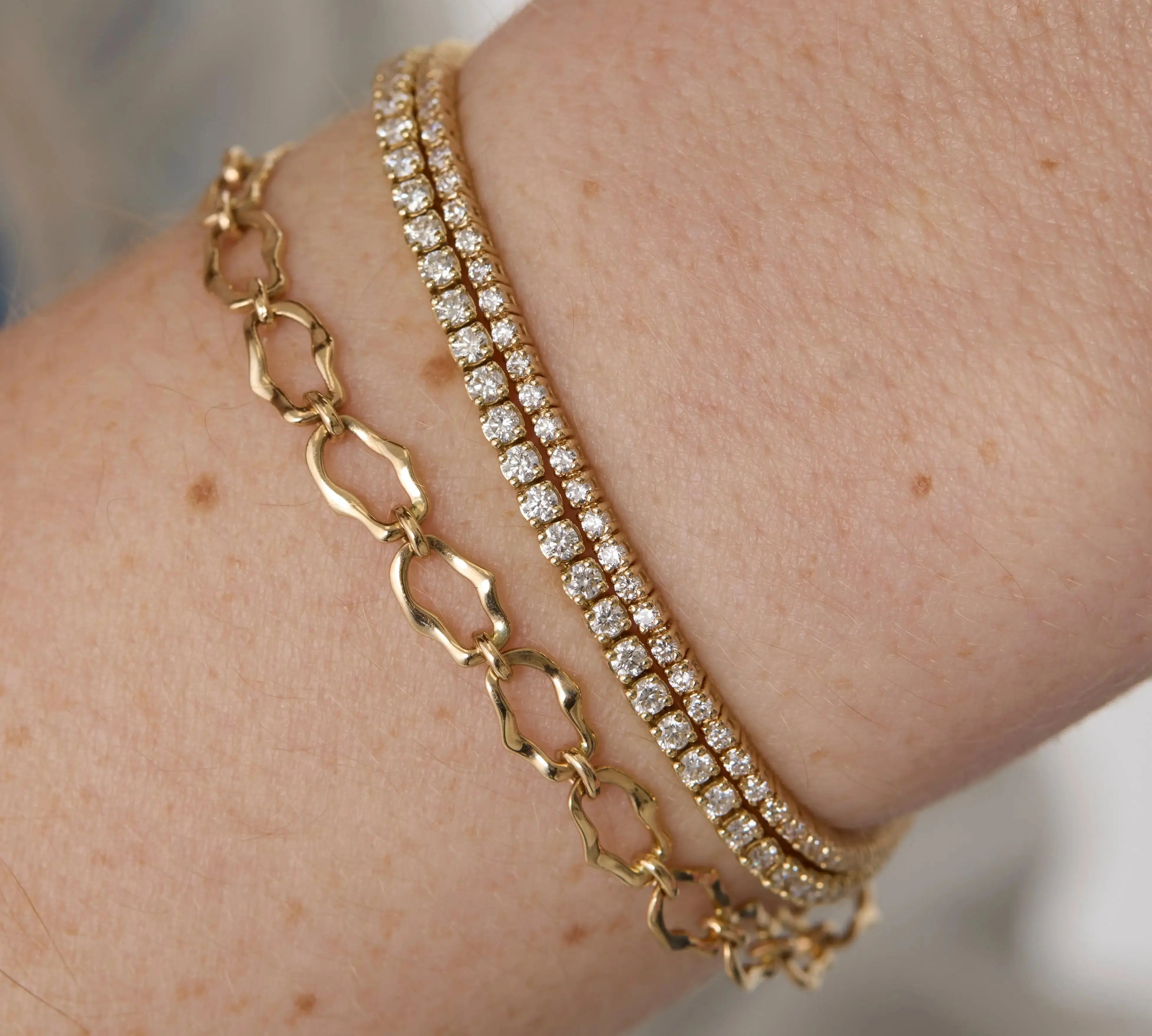 Close up of woman's wrist spotlighting multiple Marrow Fine bracelets