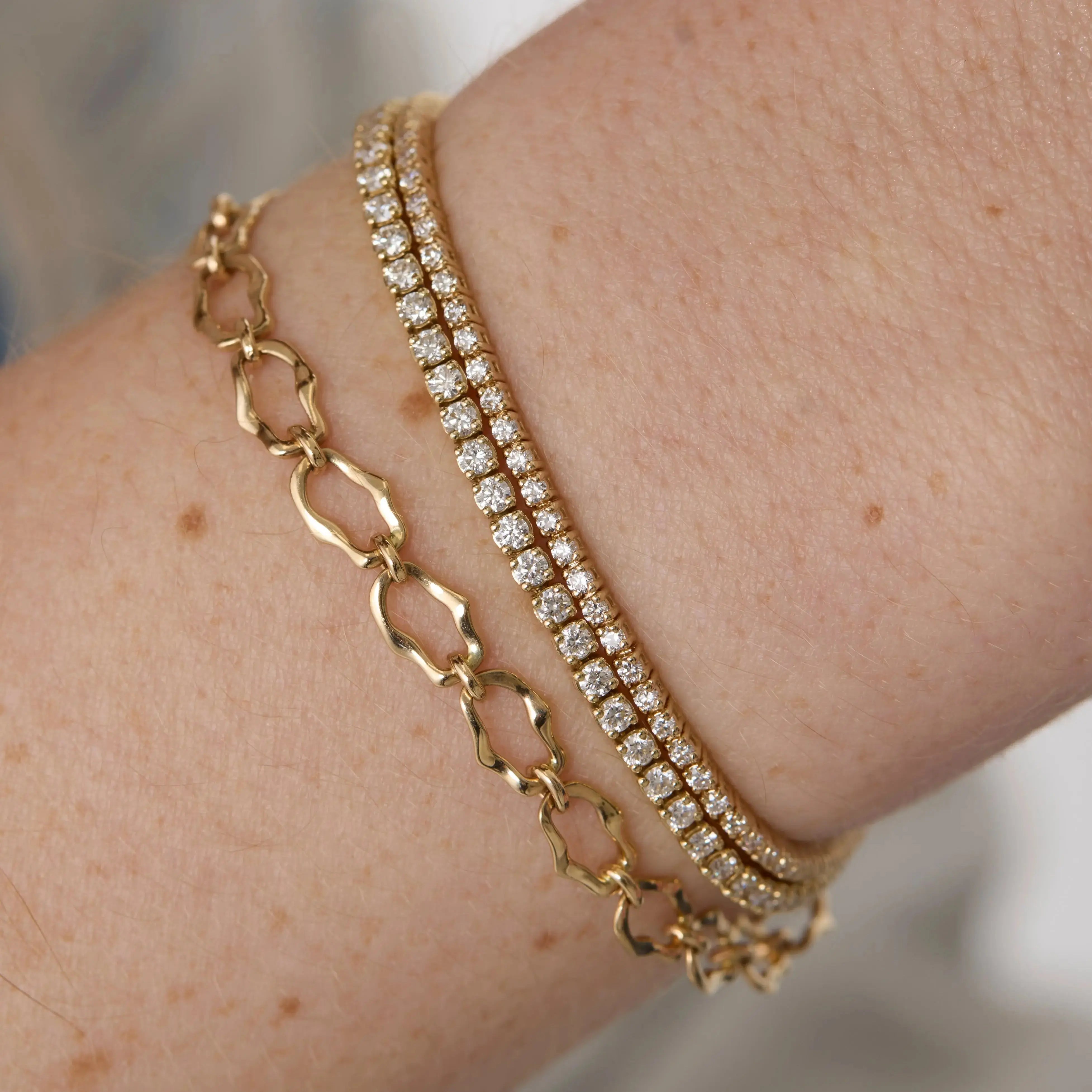 Close up of woman's wrist spotlighting multiple Marrow Fine bracelets