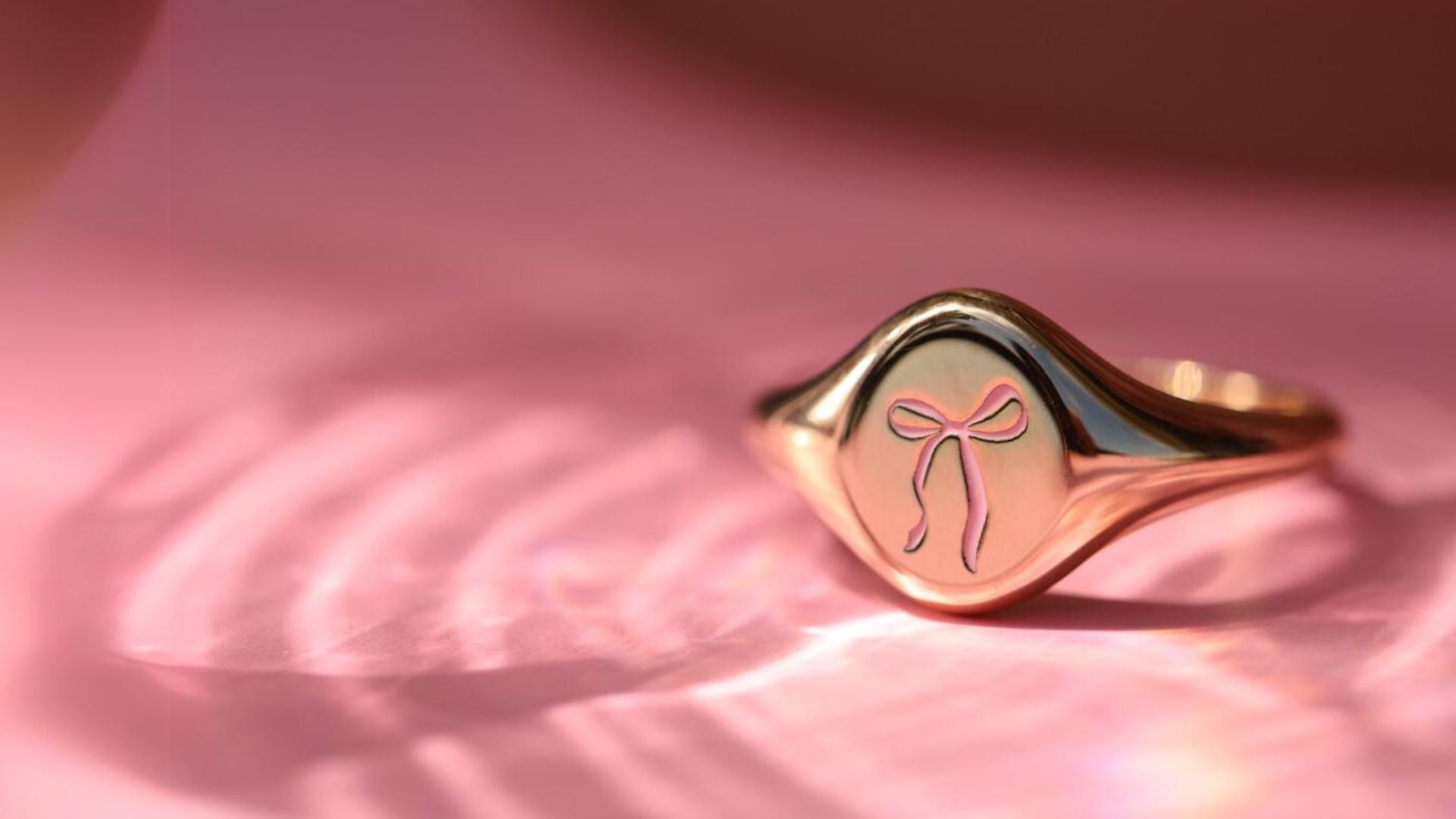 Flatlay of new limited edition Pink Enamel Bow Signet Ring