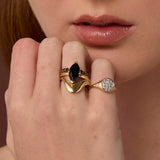 Close up of woman resting hand against her chin, highlighting multiple Marrow Fine rings styled and stacked together