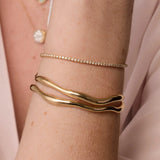Coco Tennis Bracelet & Curved Freeform Gold Cuff close up of woman's wrist