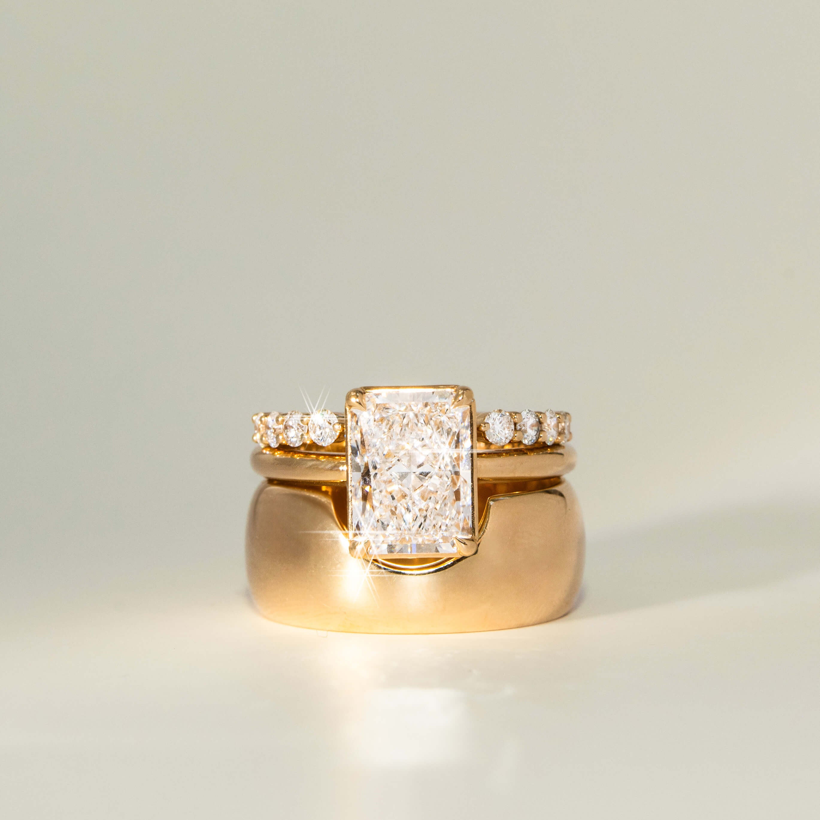Gold ring with diamond accents on a light gray background