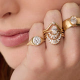 Close up of woman resting hand agains her chin, highlighting multiple Marrow Fine diamond rings