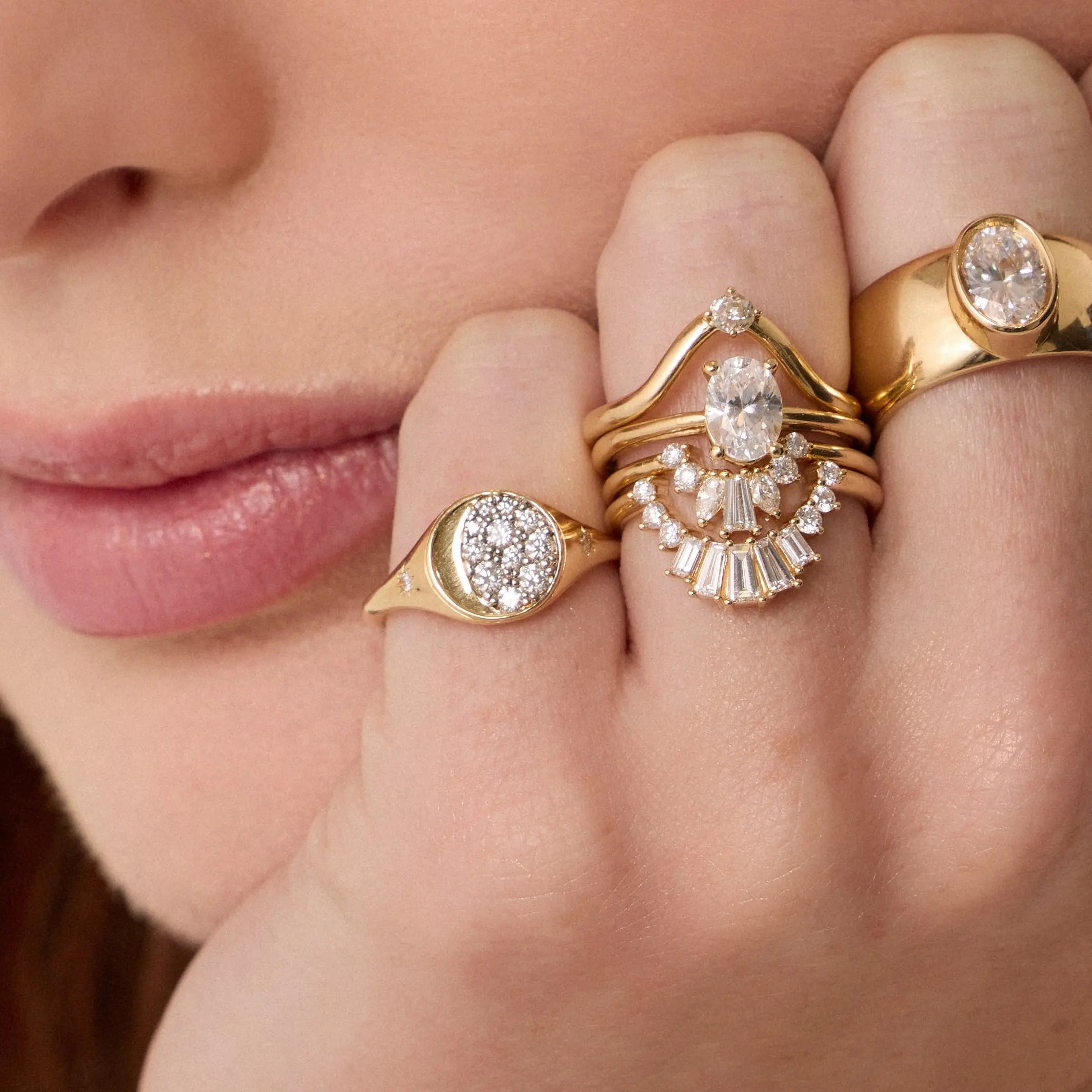 Close up of woman resting hand agains her chin, highlighting multiple Marrow Fine diamond rings