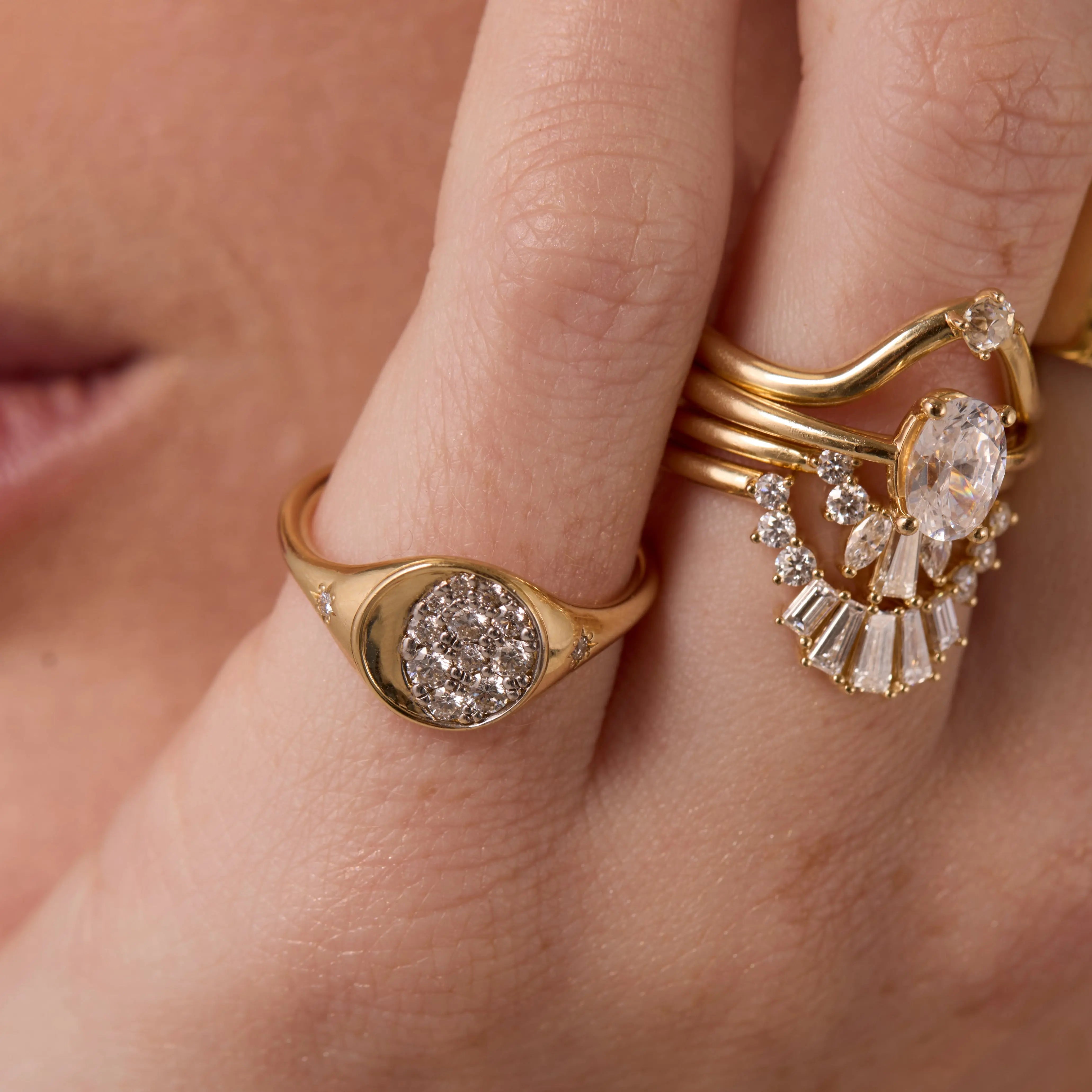 Close up of woman resting hand agains her chin, highlighting multiple Marrow Fine diamond rings