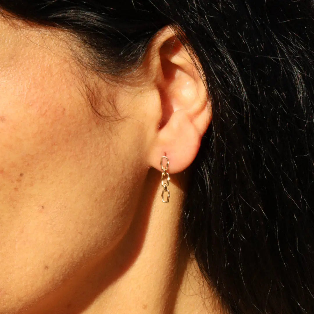 Close up of woman's ear featuring the Marrow Fine 6mm Sculpted Link Gold Earrings