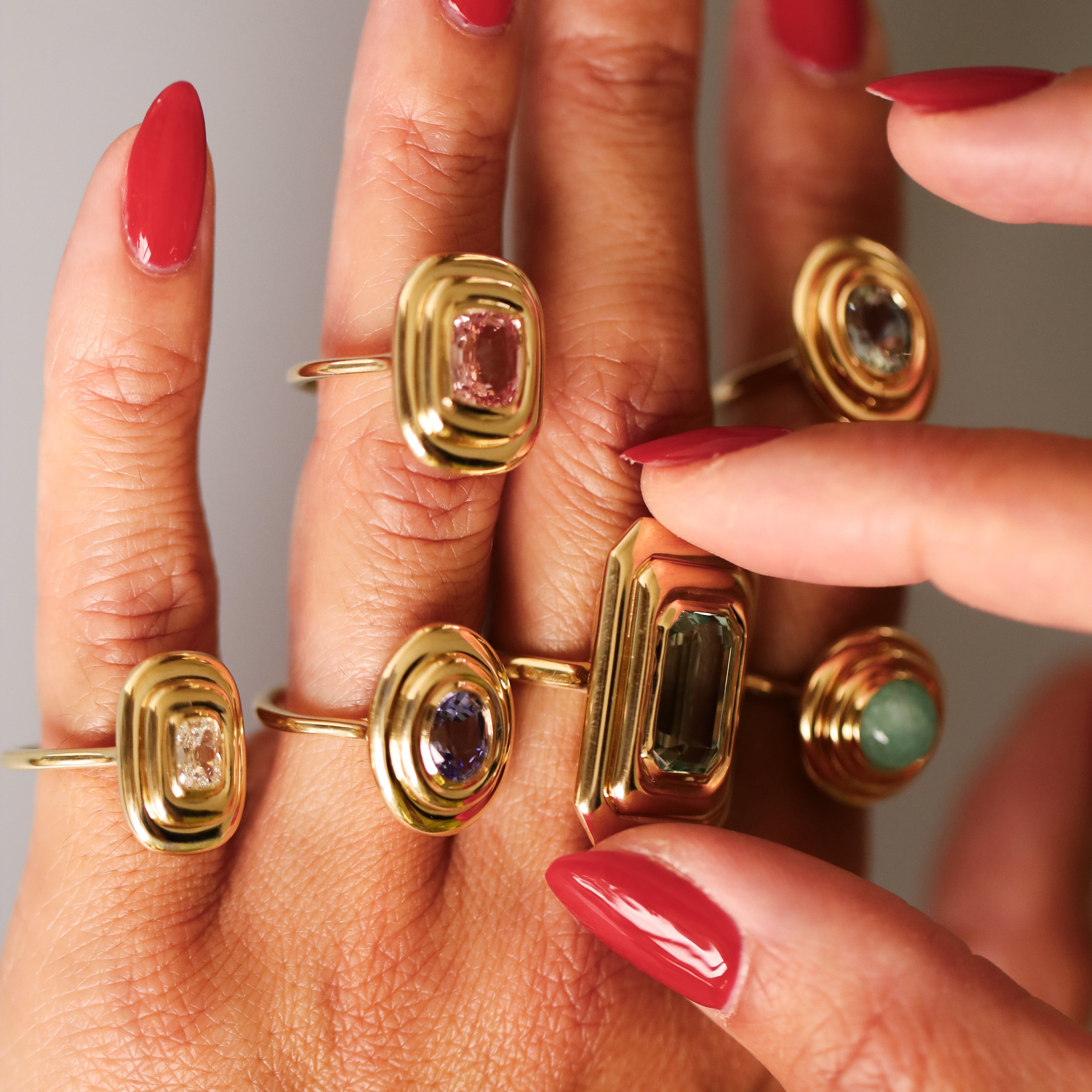 Close up of multiple In Orbit rings stacked on woman's hand