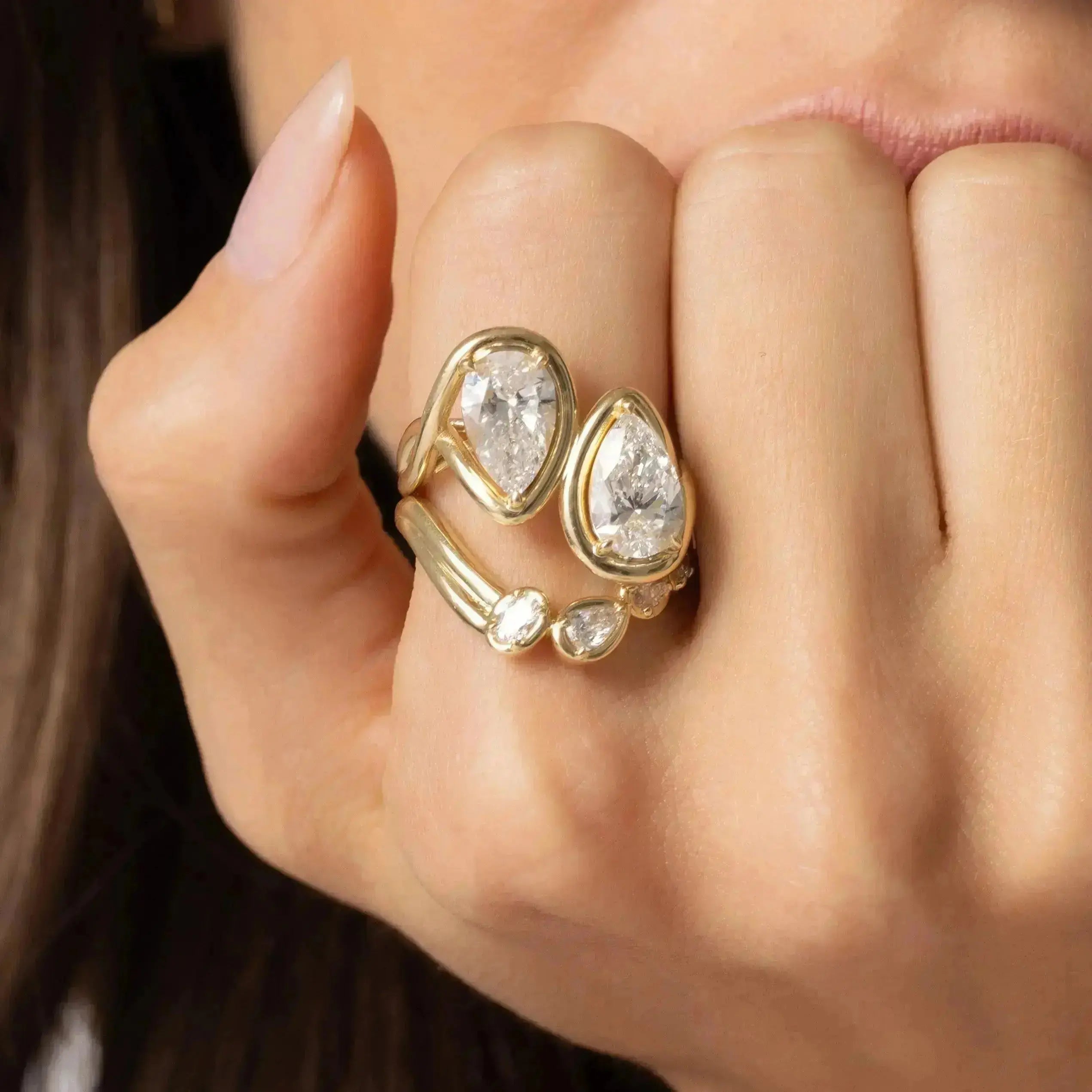 Close up of Joanie Bypass Ring and Simone Arch Band stacked on woman's finger