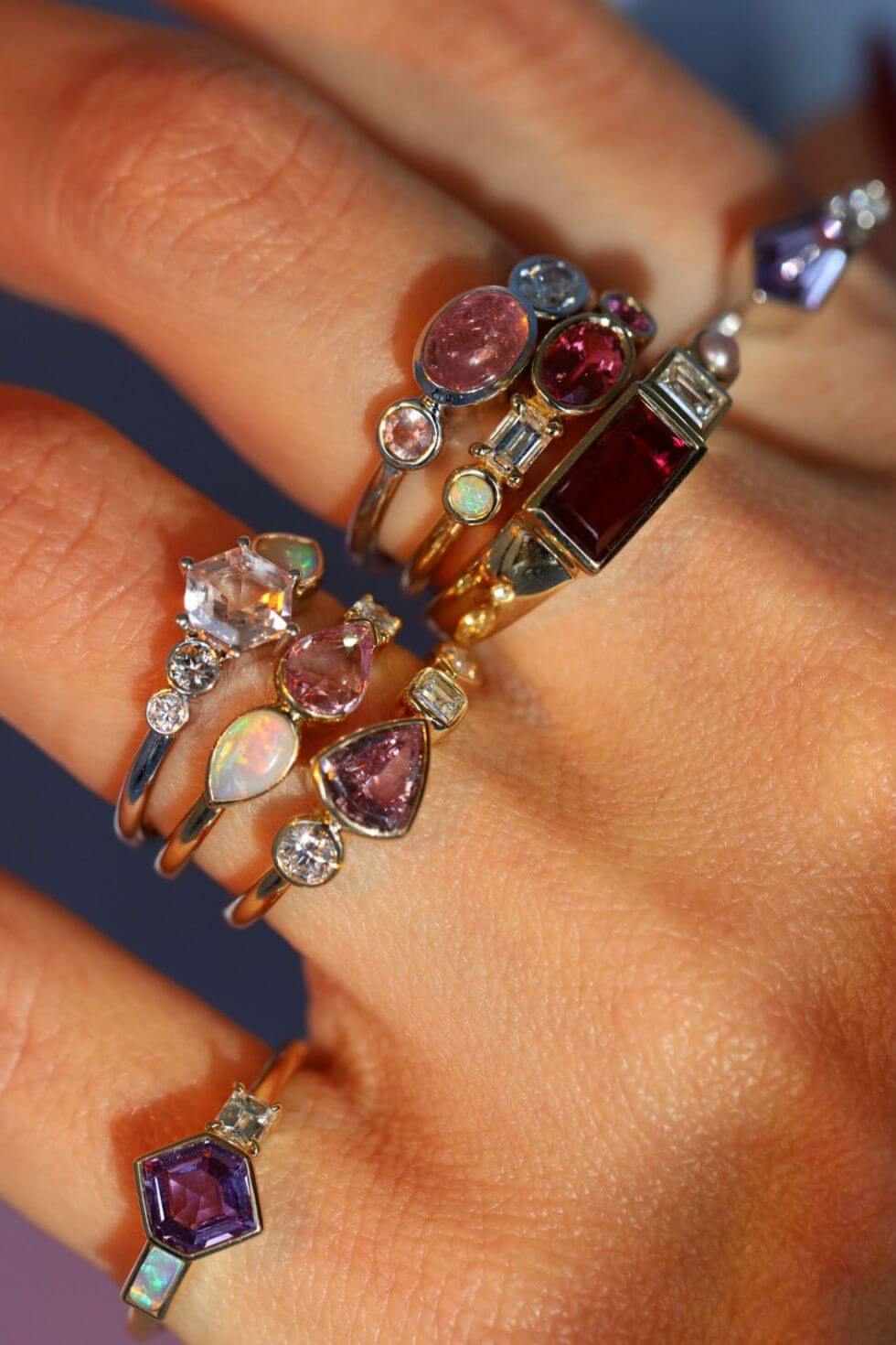 close up of hand with multiple rings stacked together, from the Kaleidoscope collection