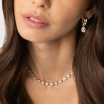 Close up of woman waring Odette Oval Drop Earrings and Lisse Tennis Necklace