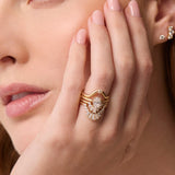 Close up of woman's resting on her jaw, highlighting multiple Marrow Fine diamond rings stacked together