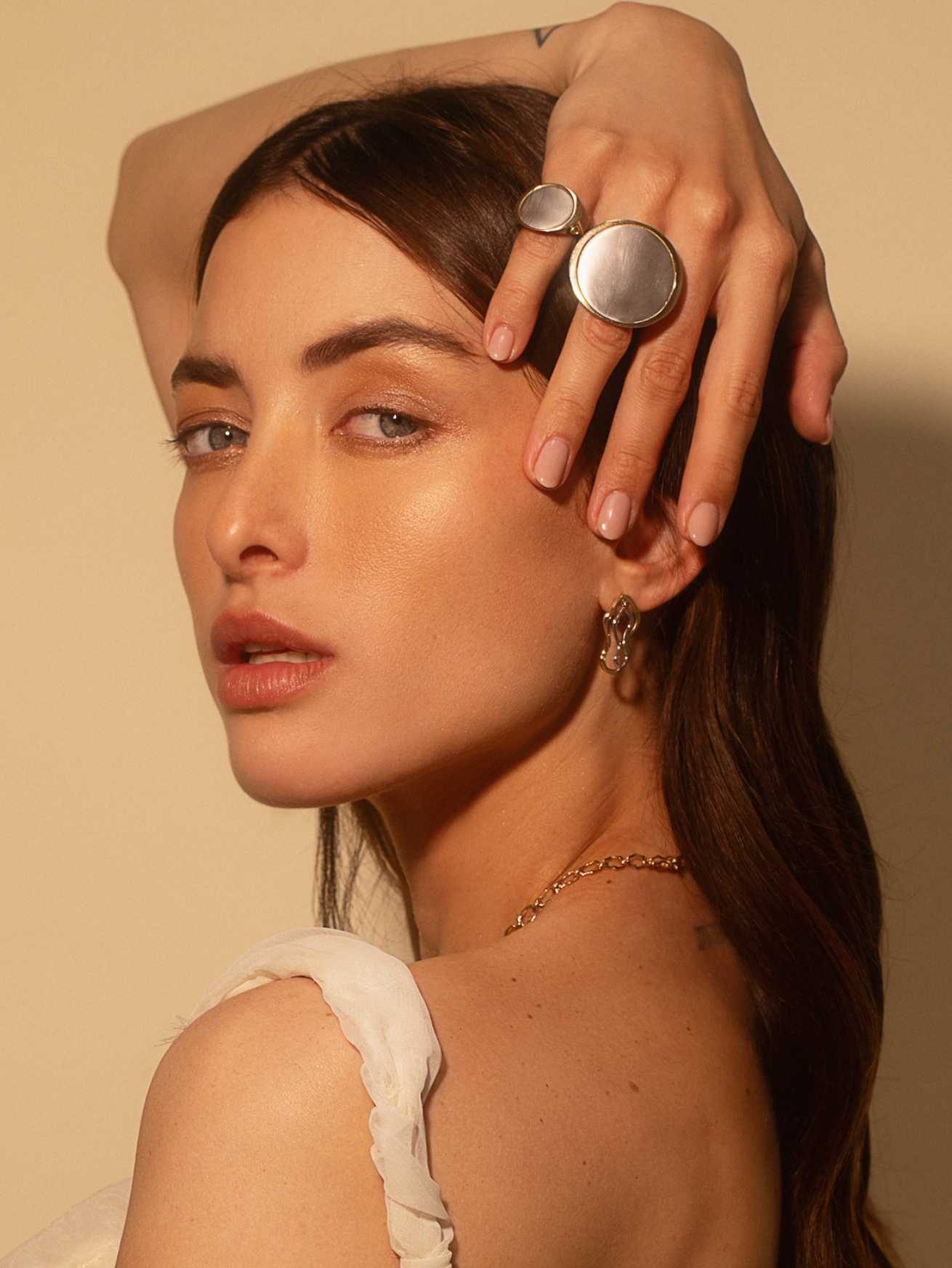 Close up of woman with hand above her head wearing Marrow Fine Jewelry