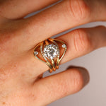 Gold ring with a diamond on a hand against a neutral background