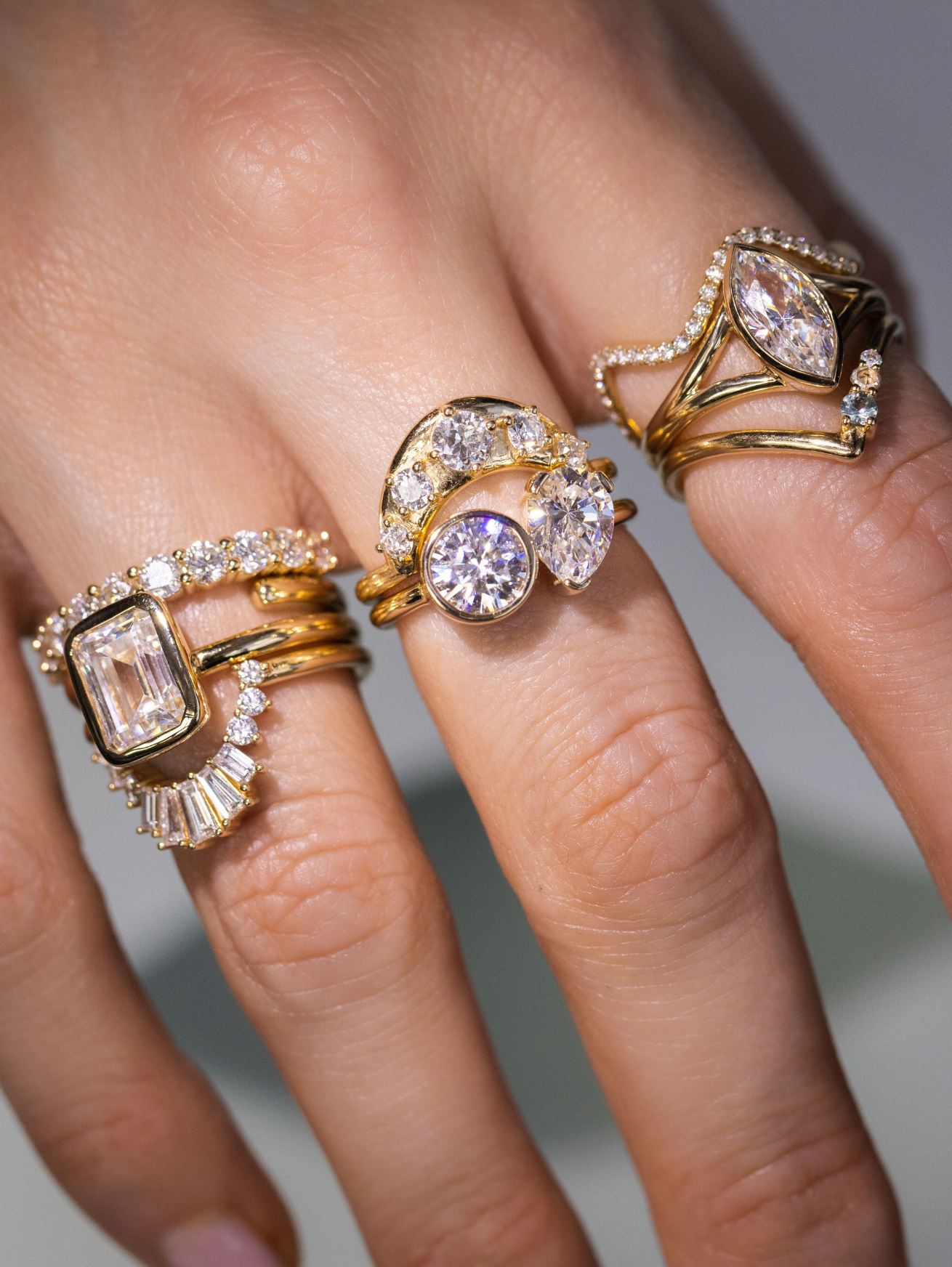 hand with multiple Marrow Fine white diamond rings stacked together