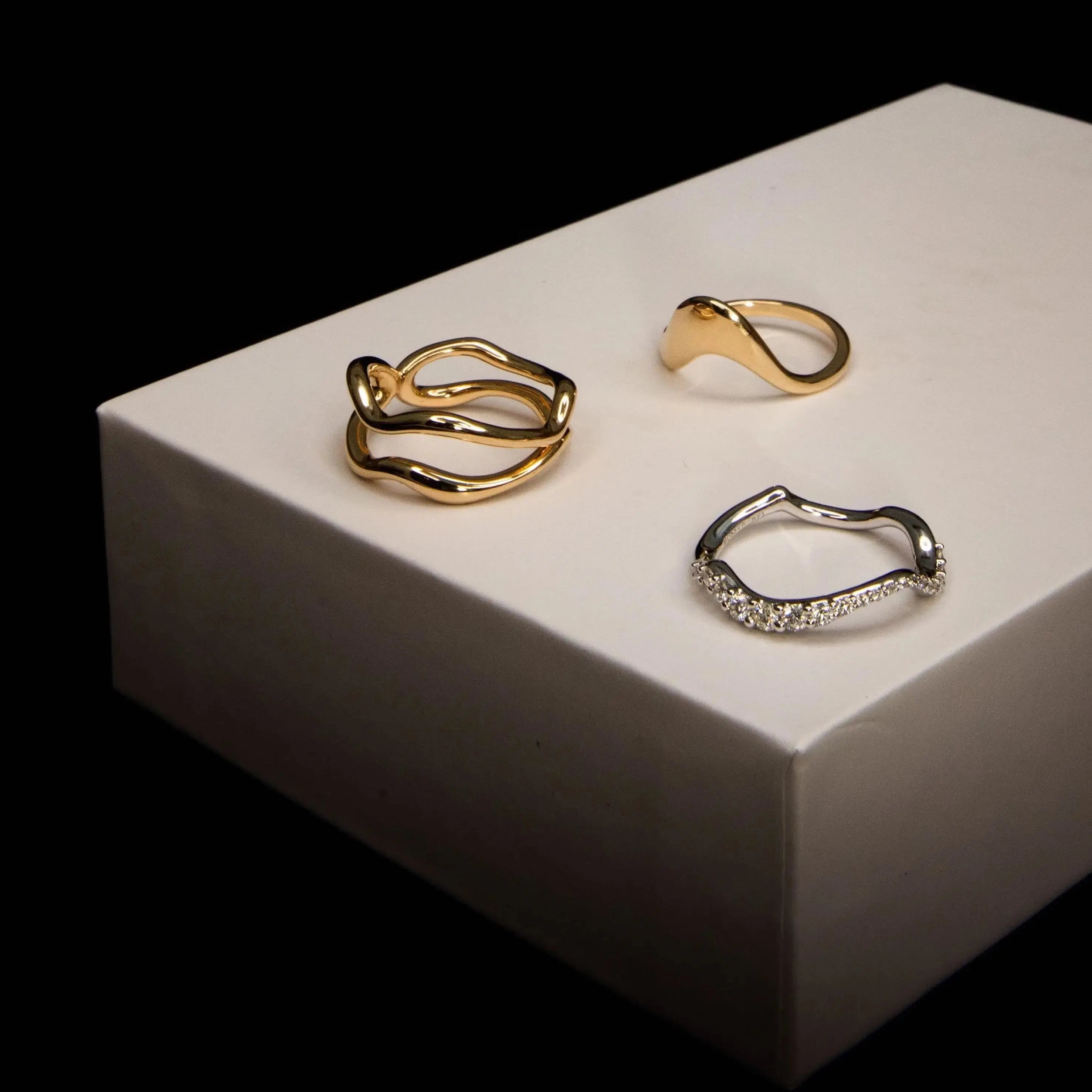 Flat lay of Freeform Gold Ring, Asymmetrical Sculpted Band and White Diamond Pave Ring