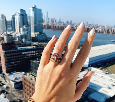 hand with Marrow Fine rings over city landscape