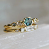 Two gold rings with gemstones on a light background