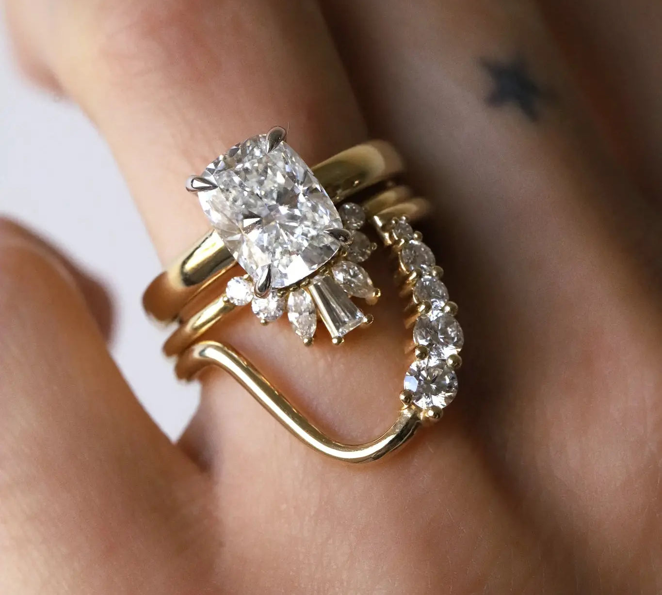 White diamond cushion engagement ring with two stacking bands