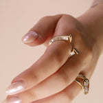 close up of horseshoe ring with baguette diamonds on finger