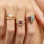Three gold rings with gemstones on a hand