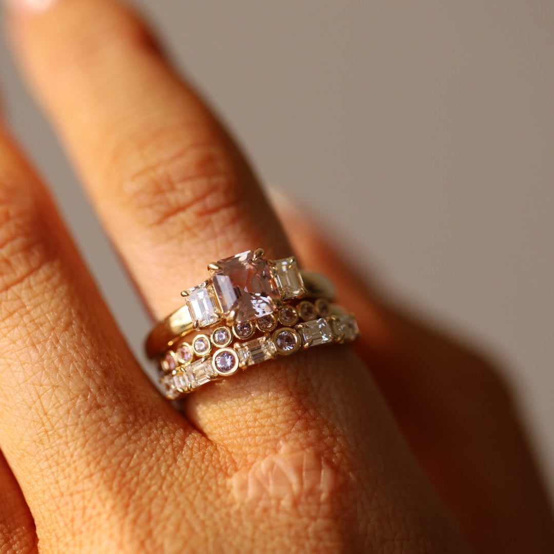 Close up of 1.76ct Pink Sapphire and Diamond Ring with Cosmic Light & Third Band on finger
