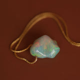 opal pendant on dark background