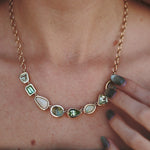 Necklace with green gemstones worn by a person