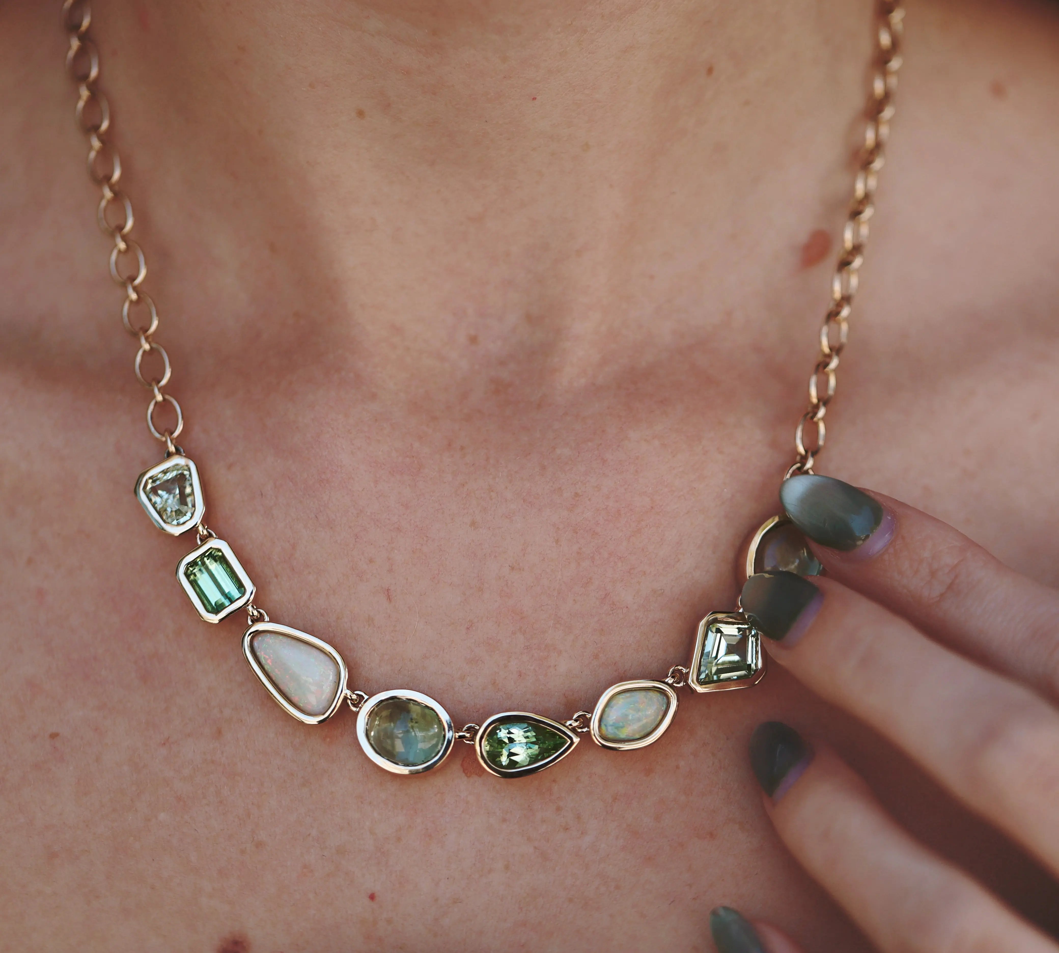 Necklace with green gemstones worn by a person