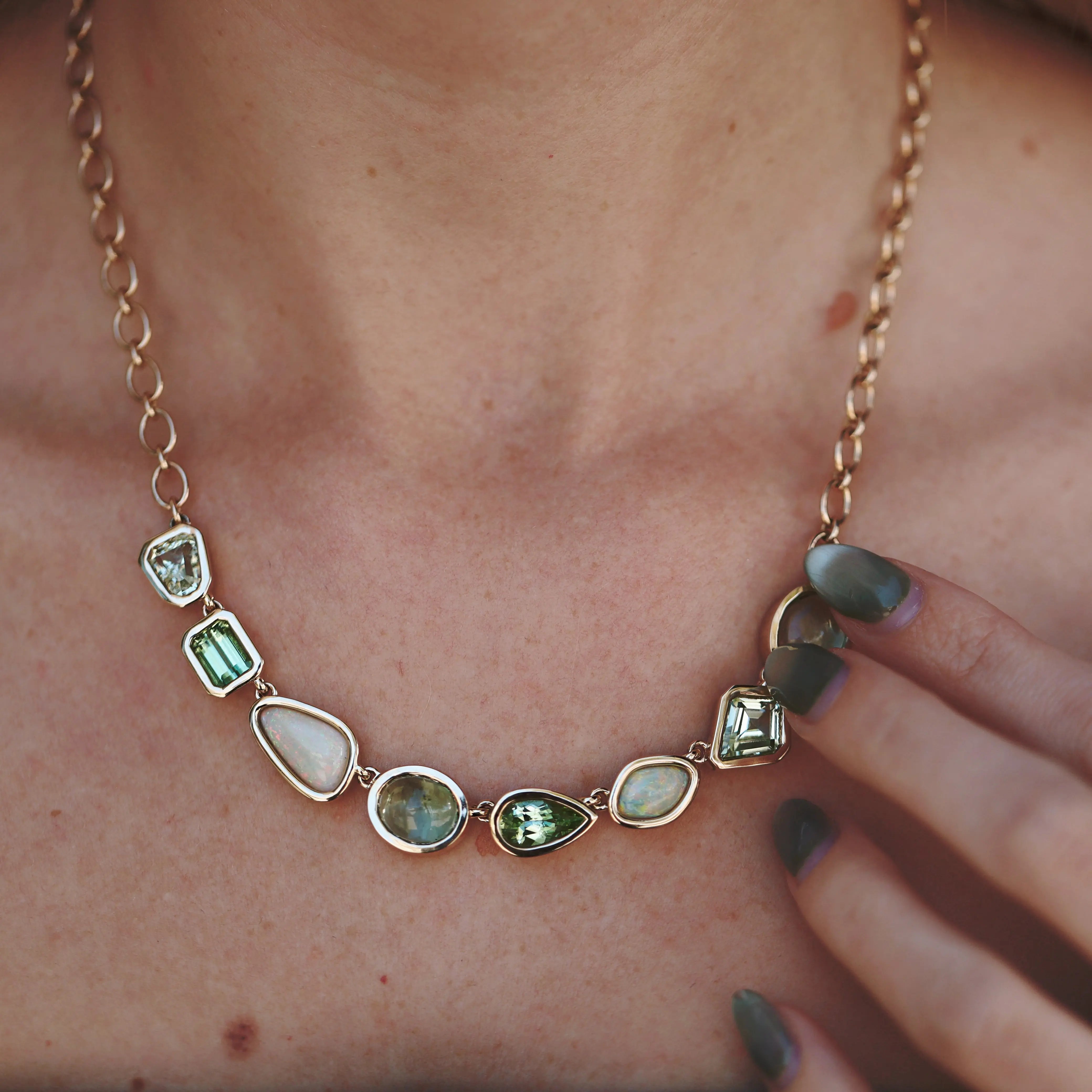 Necklace with green gemstones worn by a person