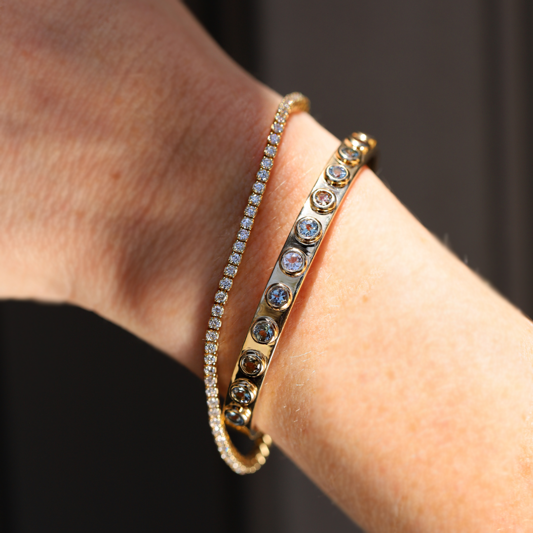 2.02tcw Tanzanite Cuff shot on a person's wrist styled with the White Diamond Maria Tennis Bracelet. 