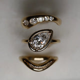 Gold ring with diamond accents on a neutral background