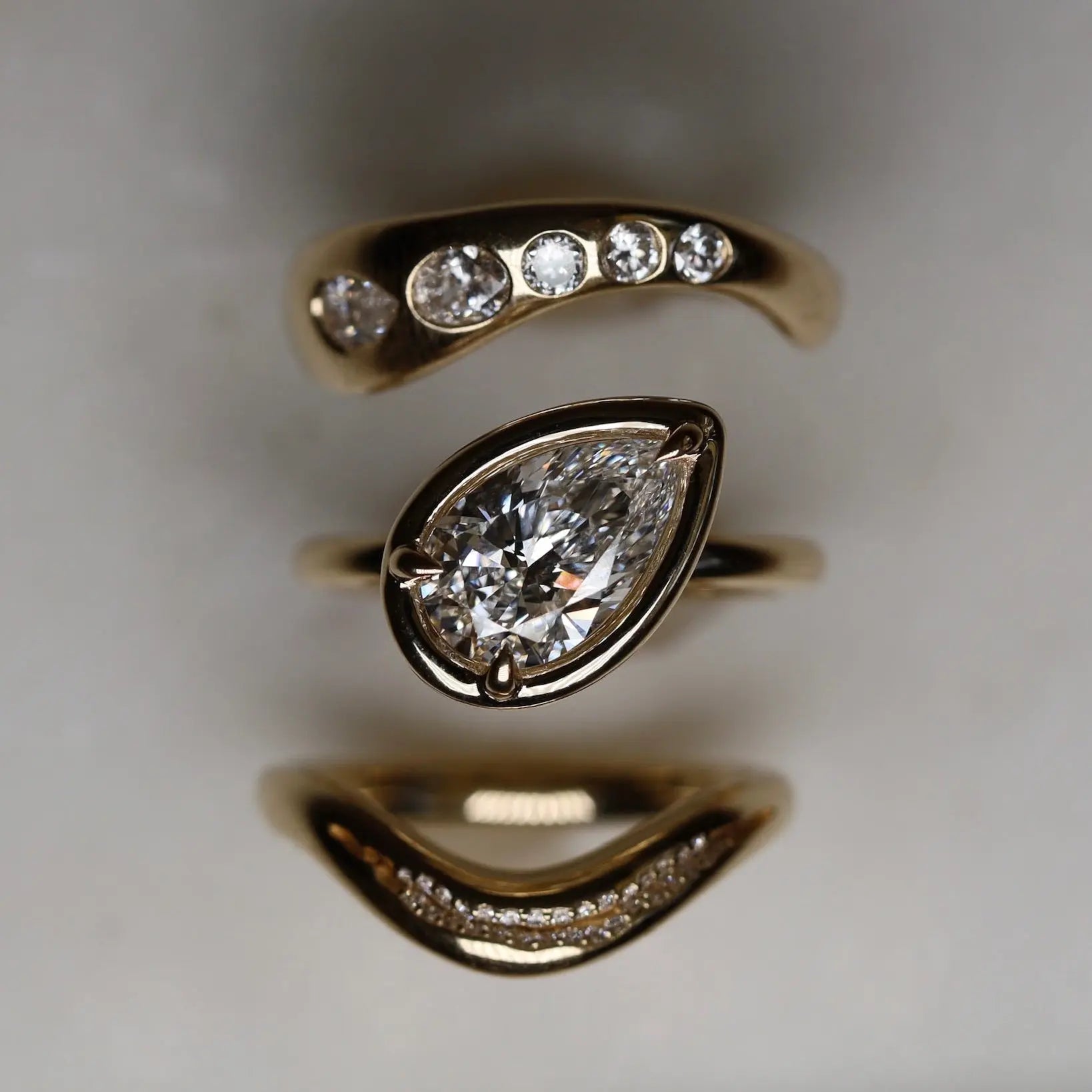 Gold ring with diamond accents on a neutral background