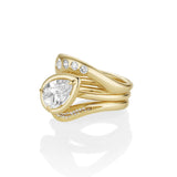 Gold ring with a large pear-shaped diamond and smaller diamonds on a white background