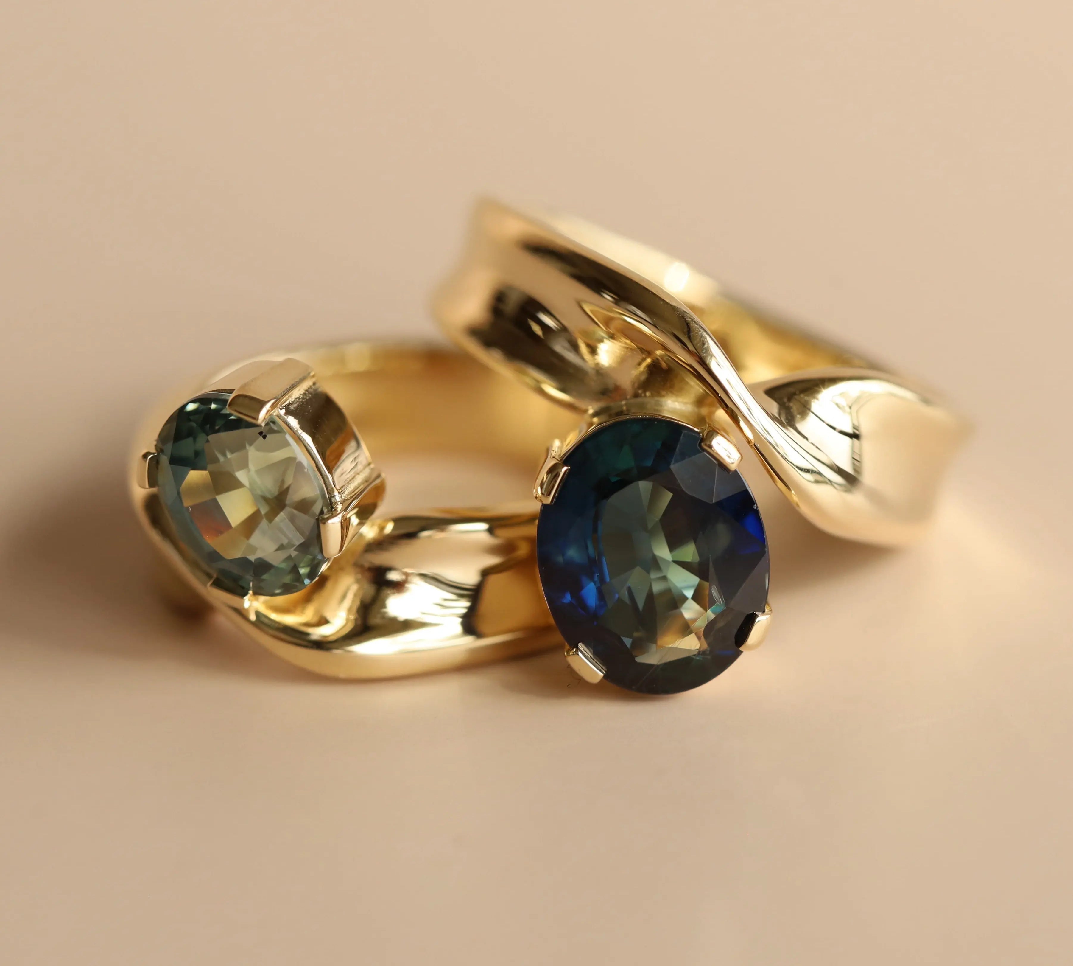 Gold ring with blue gemstones on a beige background