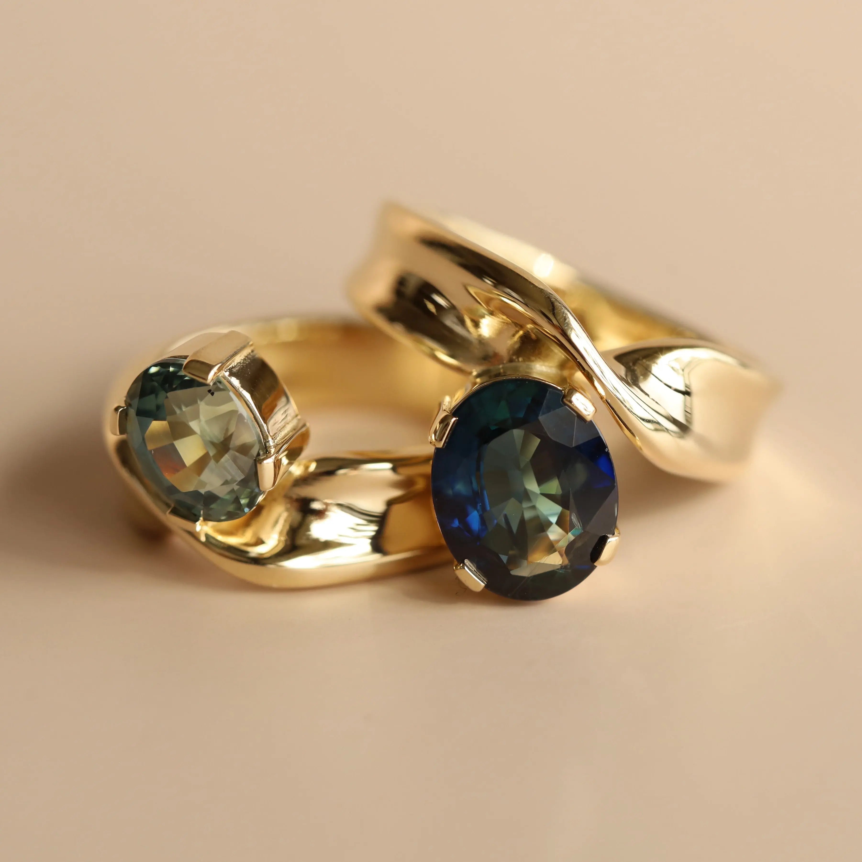 Gold ring with blue gemstones on a beige background