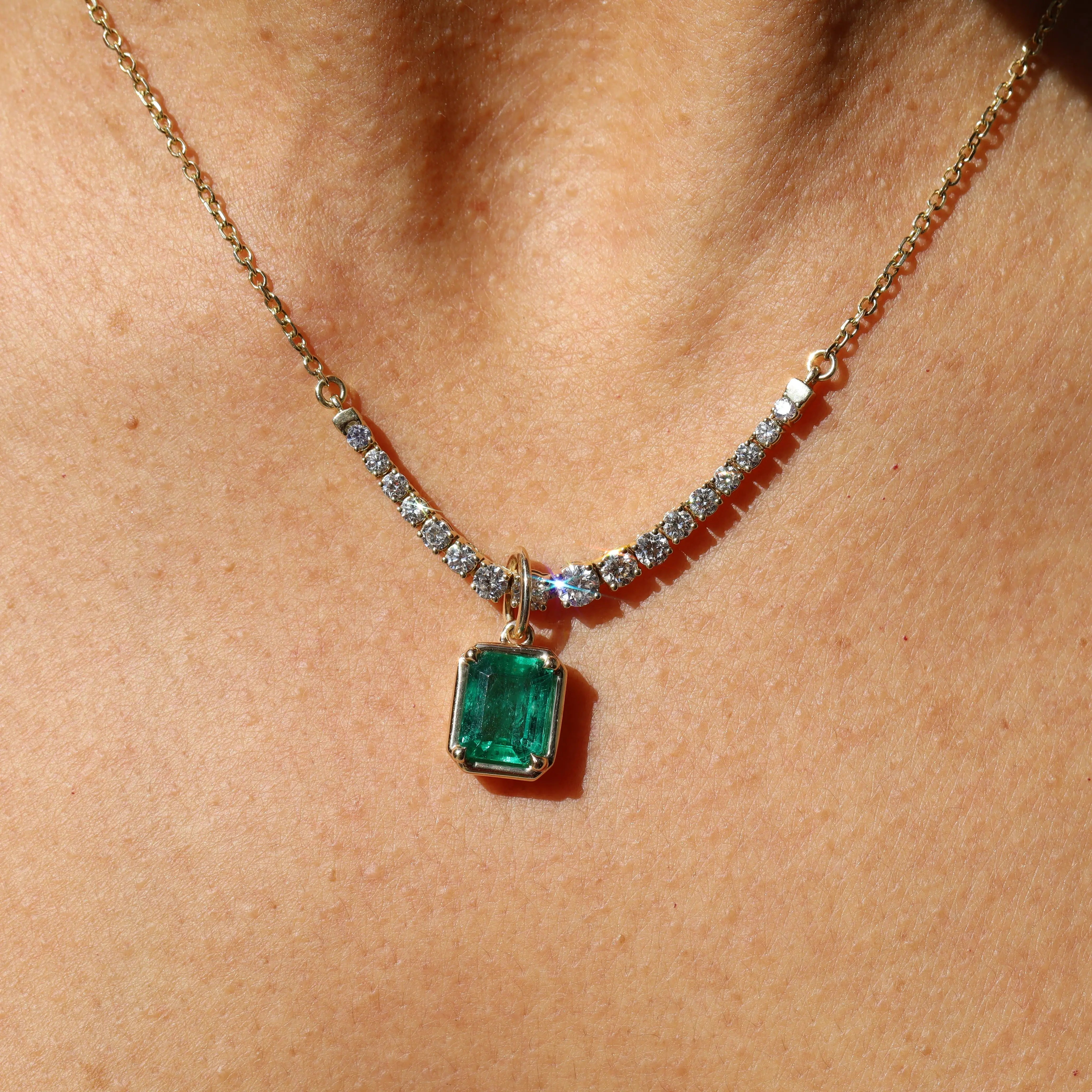 Necklace with a green gemstone pendant on a person's neck