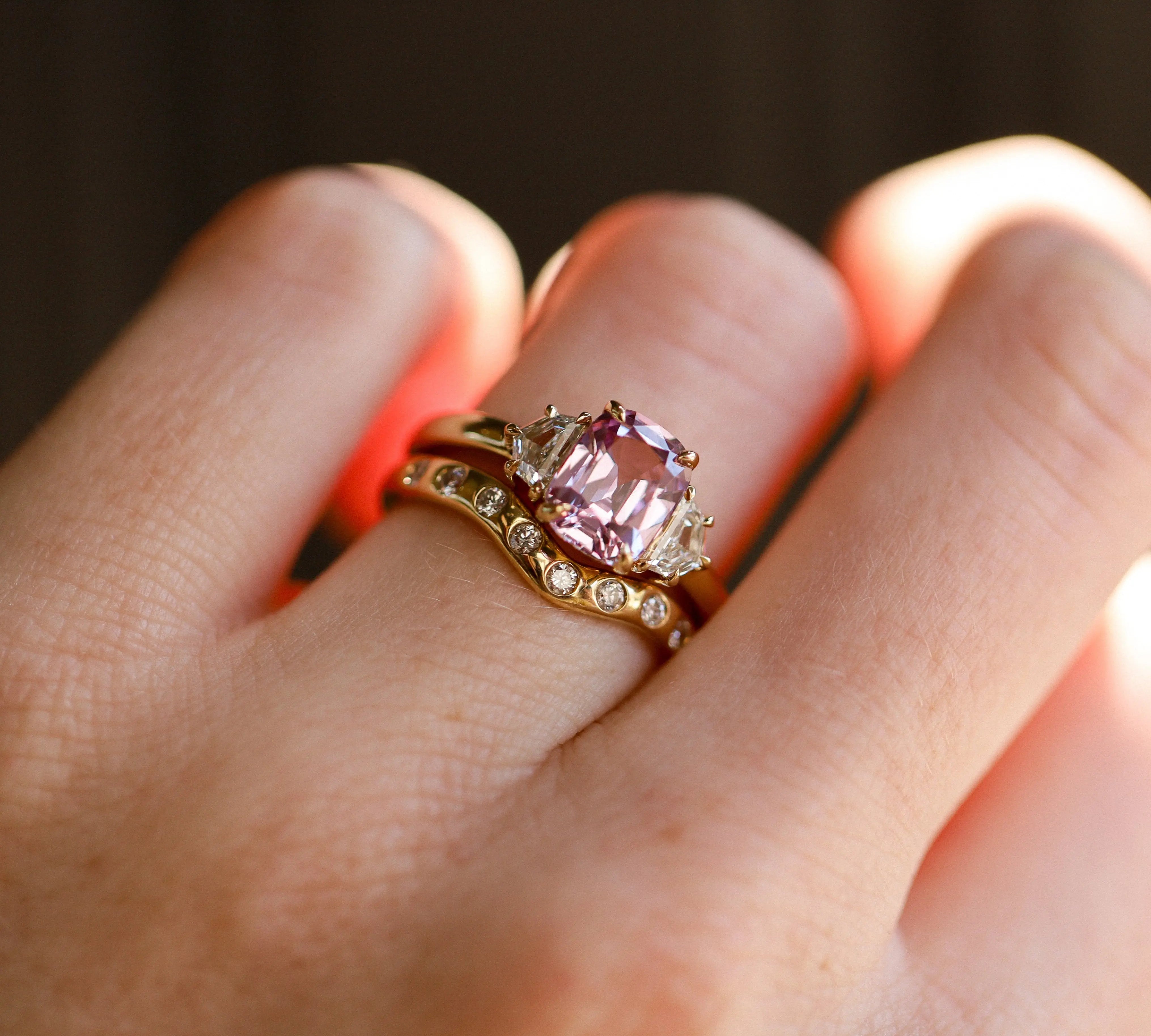 2.20ct Pink Sapphire and 0.44tcw Cadillac Diamond Three Stone Ring on hand