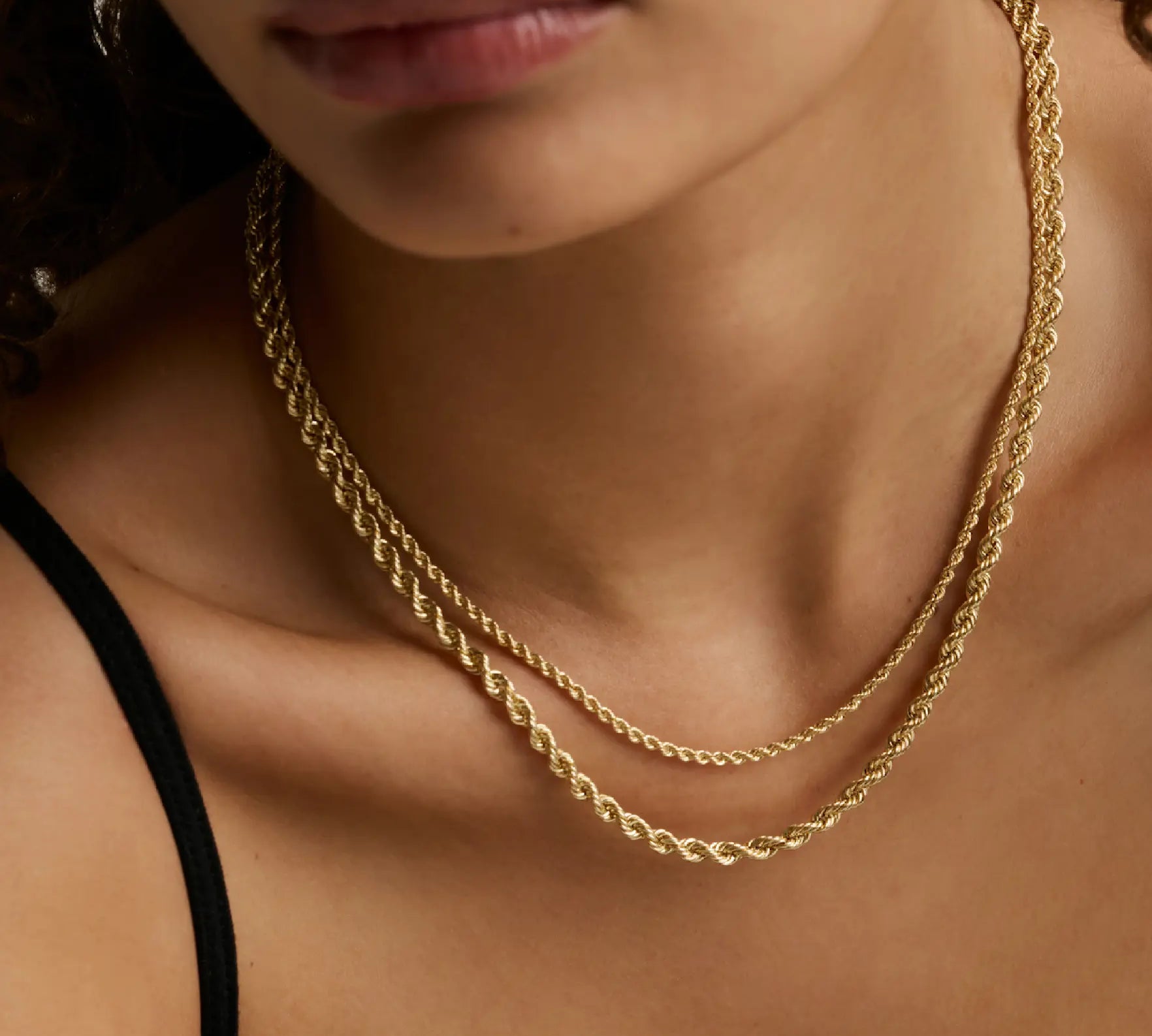 two layered yellow gold chains on woman's décolletage 