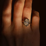 Close-up of a hand wearing a diamond ring with a dark background