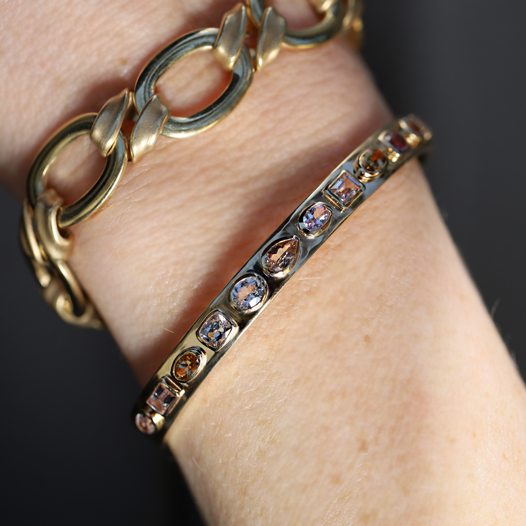 3.30tcw Fancy Tanzanite Cuff + Twist Link Bracelet shot on a person's wrist.