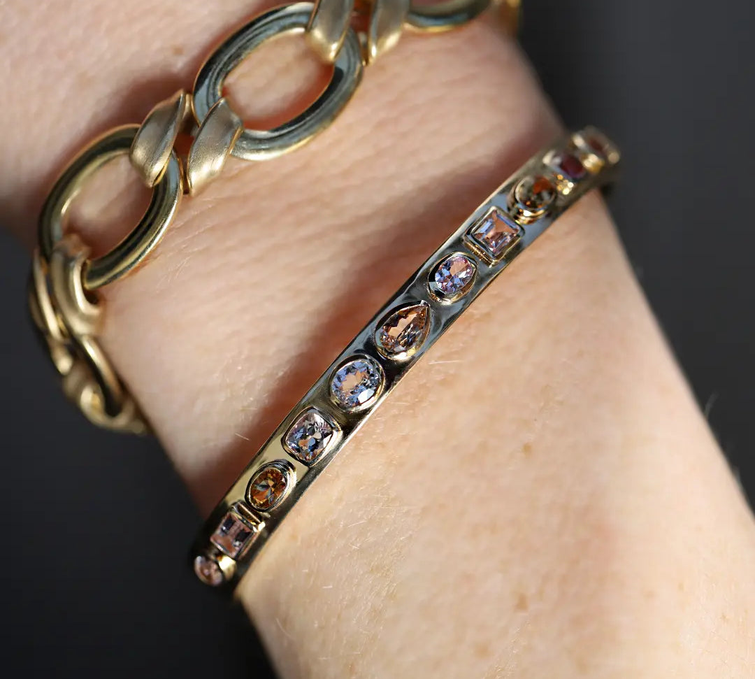 3.30tcw Fancy Tanzanite Cuff + Twist Link Bracelet shot on a person's wrist.