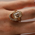 Gold diamond ring stacked with diamond band on person's hand, close up