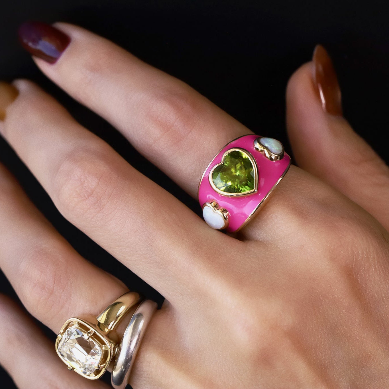 One-of-a-kind 3.81ct peridot heart ring flanked by two opal hearts on a hot pink enamel band