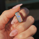 Hand with gold opal ring