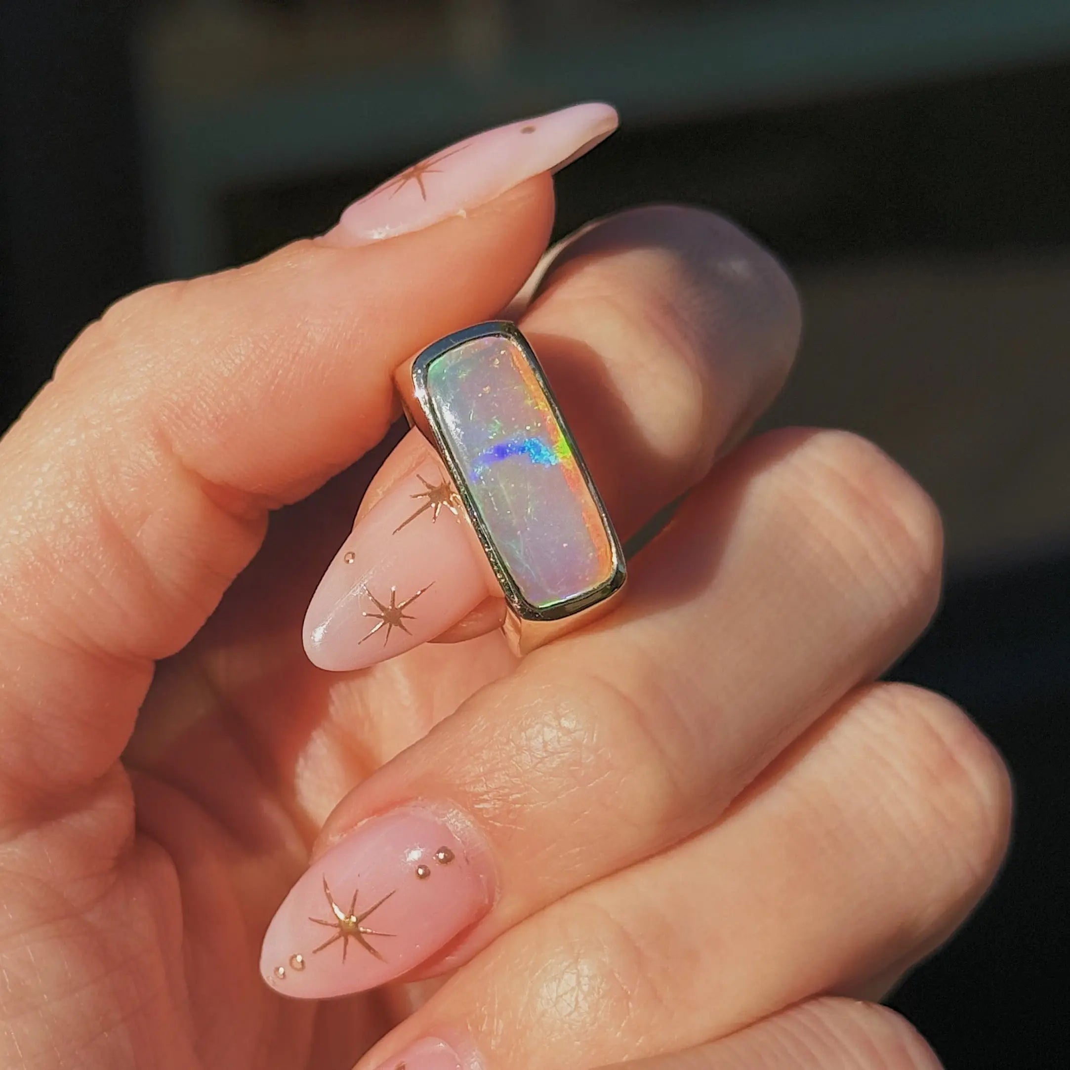 Hand with gold opal ring