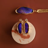 Jewelry set with purple blue opals on a brown background