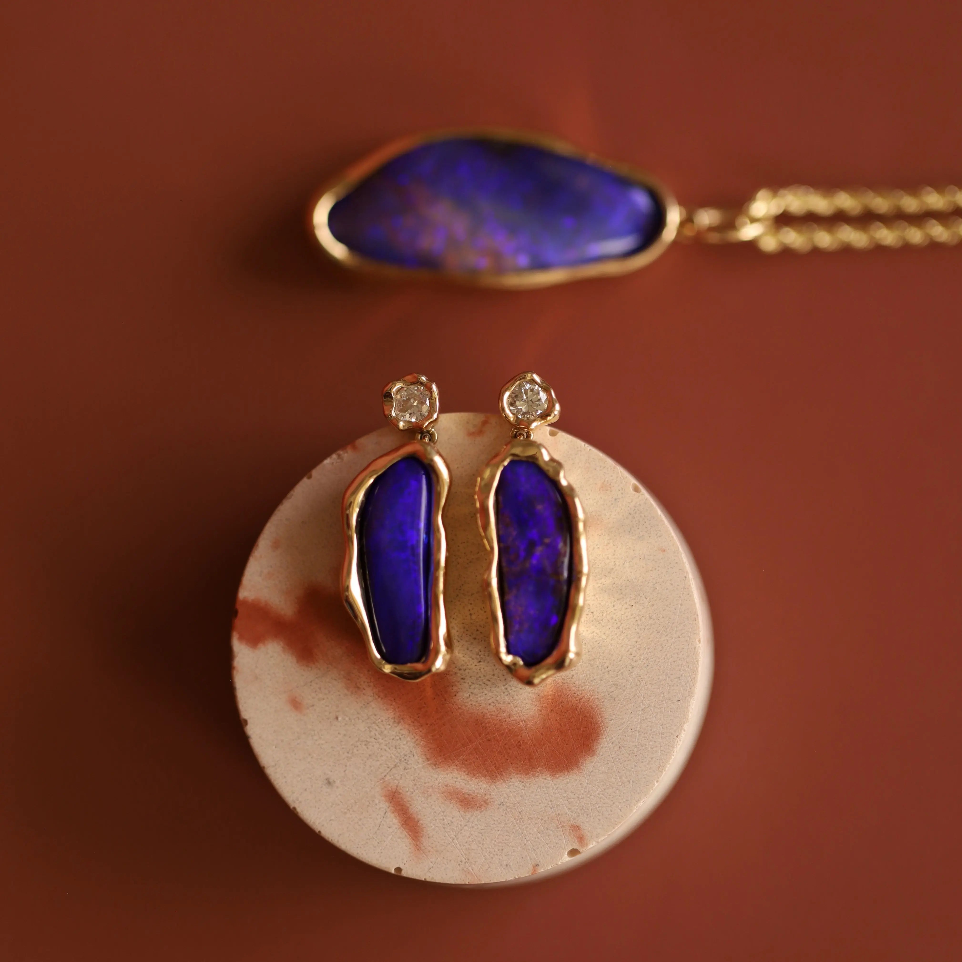 Jewelry set with purple blue opals on a brown background